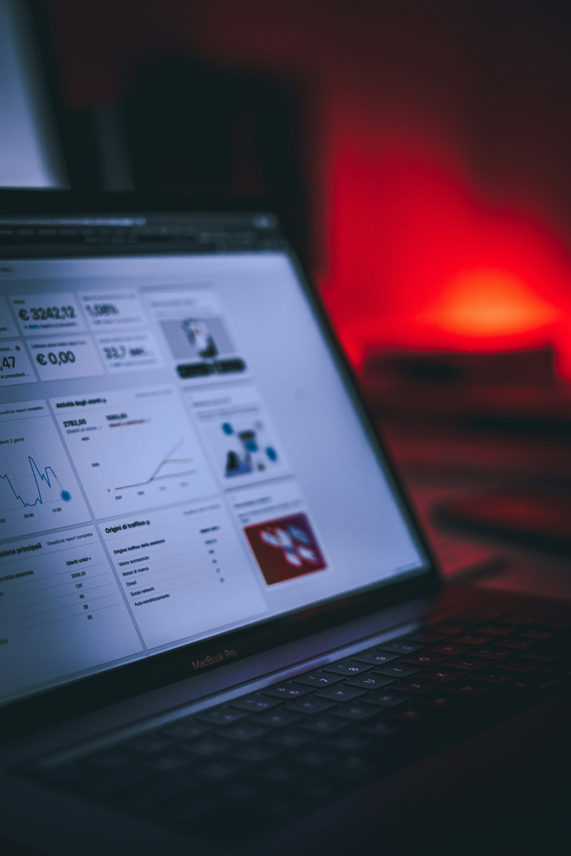 A close-up of hands working on a laptop with graphs.