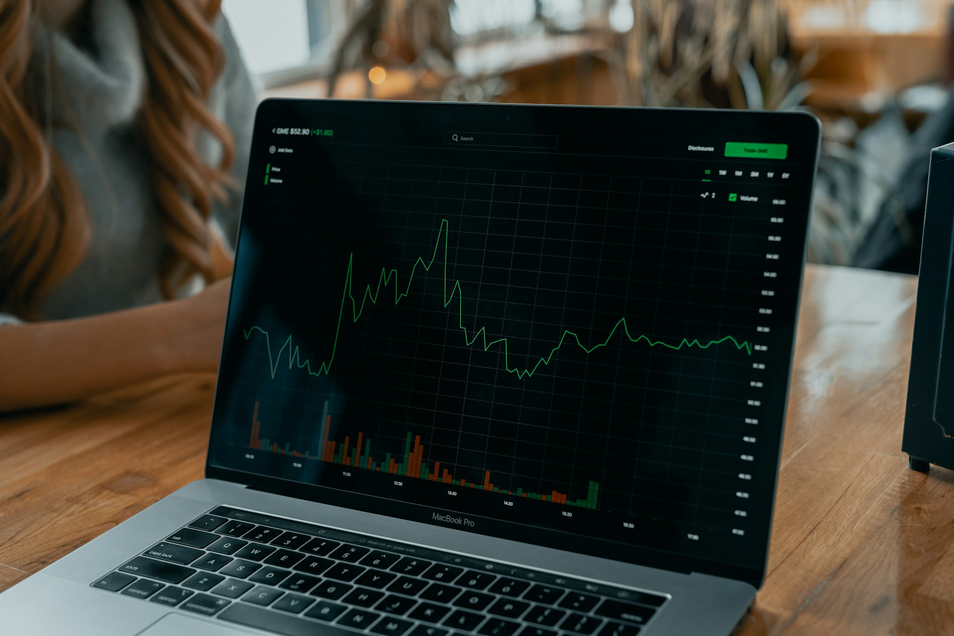 A business professional analyzing data on a laptop with charts and graphs displayed on the screen.